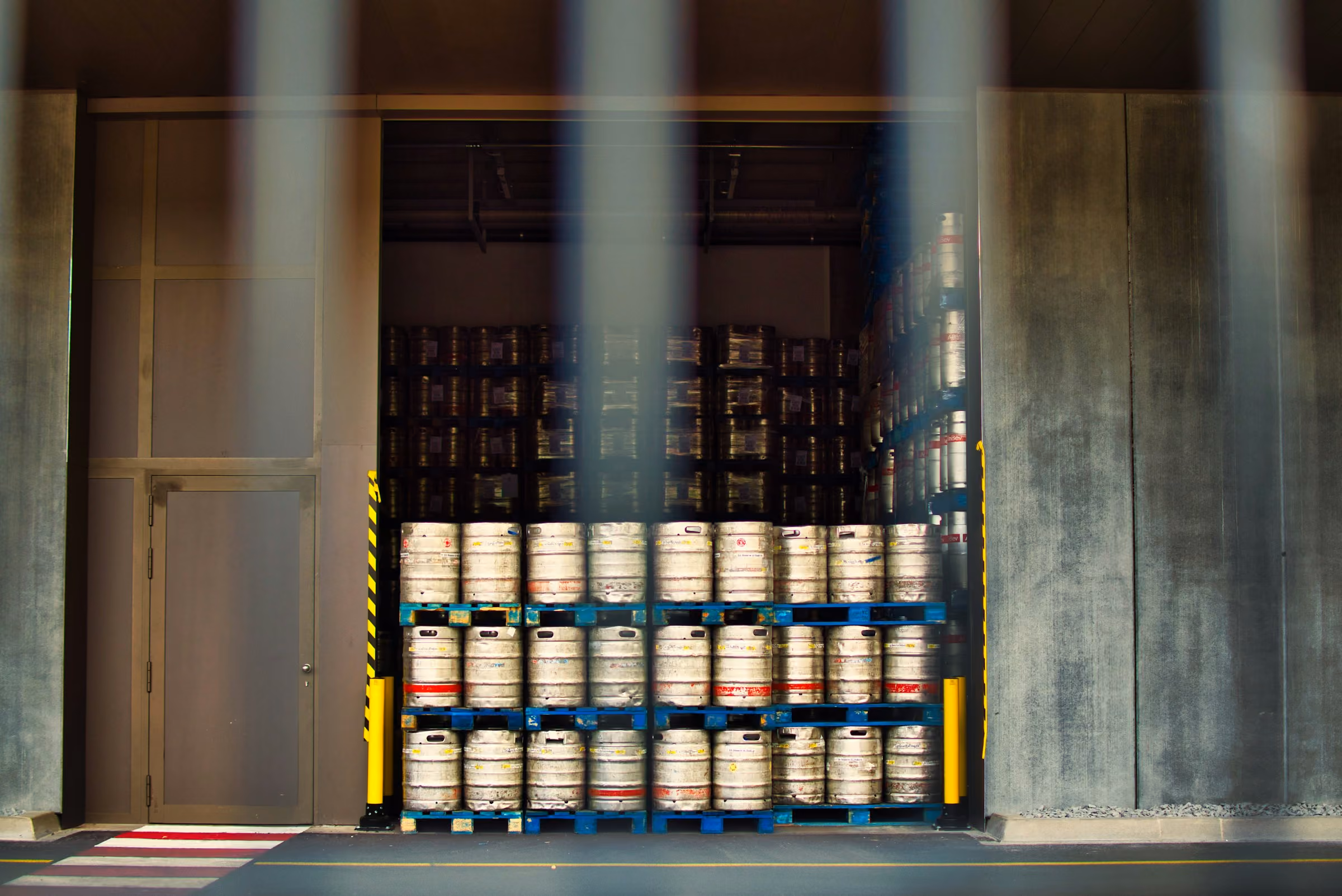 Stack of green metal barrels arranged horizontally with visible bolts on top.