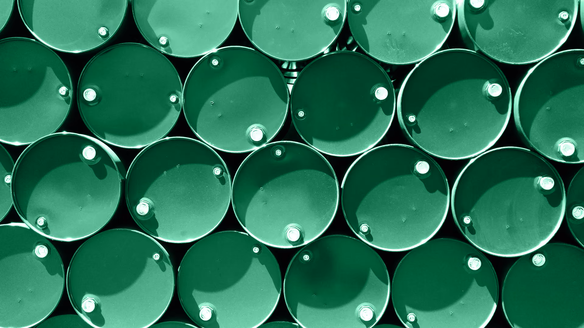 Stack of green metal barrels arranged horizontally with visible bolts on top.